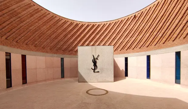Patio interior del museo Yves Saint Laurent de Marrakech, con el logotipo del diseñador y una cubierta de ladrillo de formas curvas
