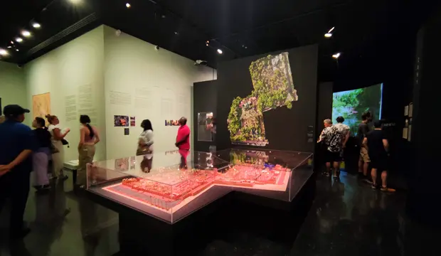 Sala de exposición del museo YSL en Marrakech, con diseños de Yves Saint Laurent, paneles informativos y visitantes