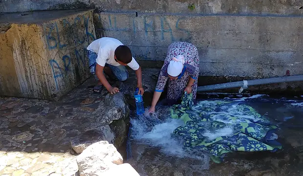 Una mujer lava su alfombra en los lavaderos de Ras el Maa, en Chefchaouen