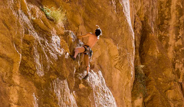Persona practicando escalada en las paredes rocosas de las gargantas del todra en Marruecos
